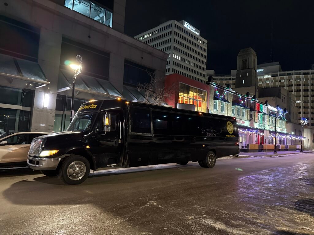 Black Regina Party Bus parked on a downtown street at night